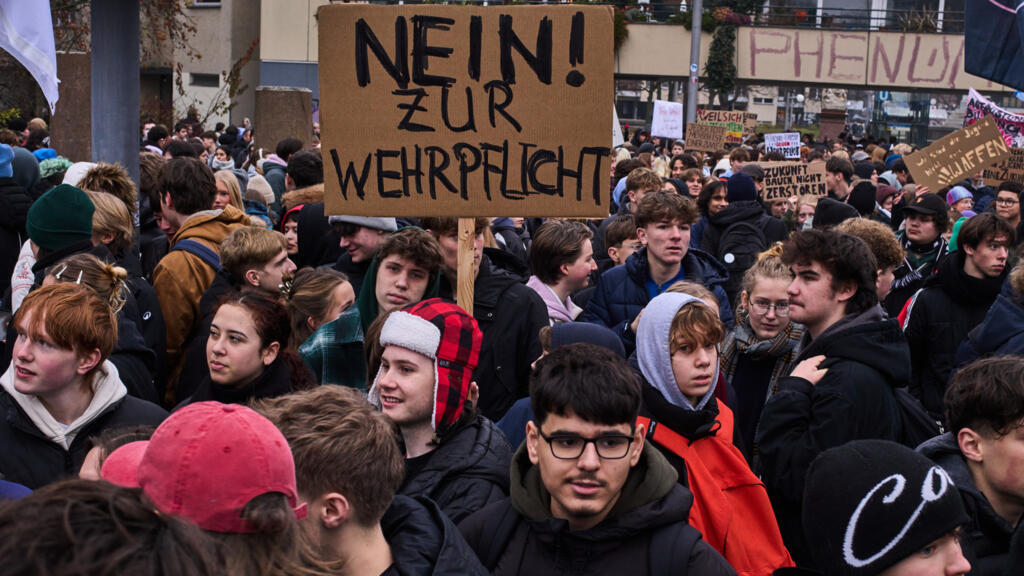 Des jeunes brandissent une affiche sur laquelle on peut lire « Non au service militaire obligatoire » lors d'une manifestation contre le projet de loi à Berlin, en Allemagne, le vendredi 5 décembre 2025.