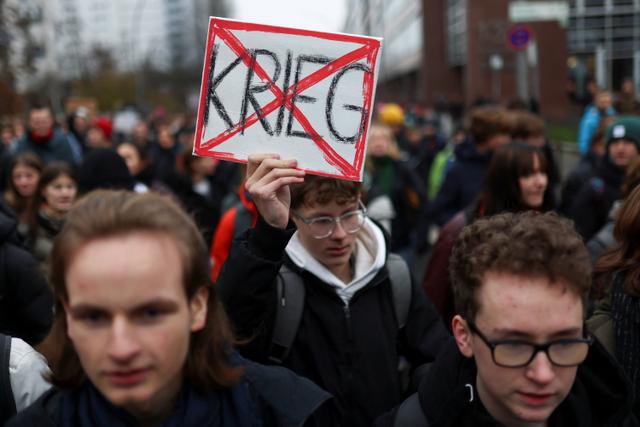 Un manifestant brandissant une pancarte indiquant “Non à la guerre”, le 5 décembre 2025, à Berlin.